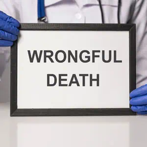  A doctor holds a board with "Wrongful Death" written on it - Mannis Law